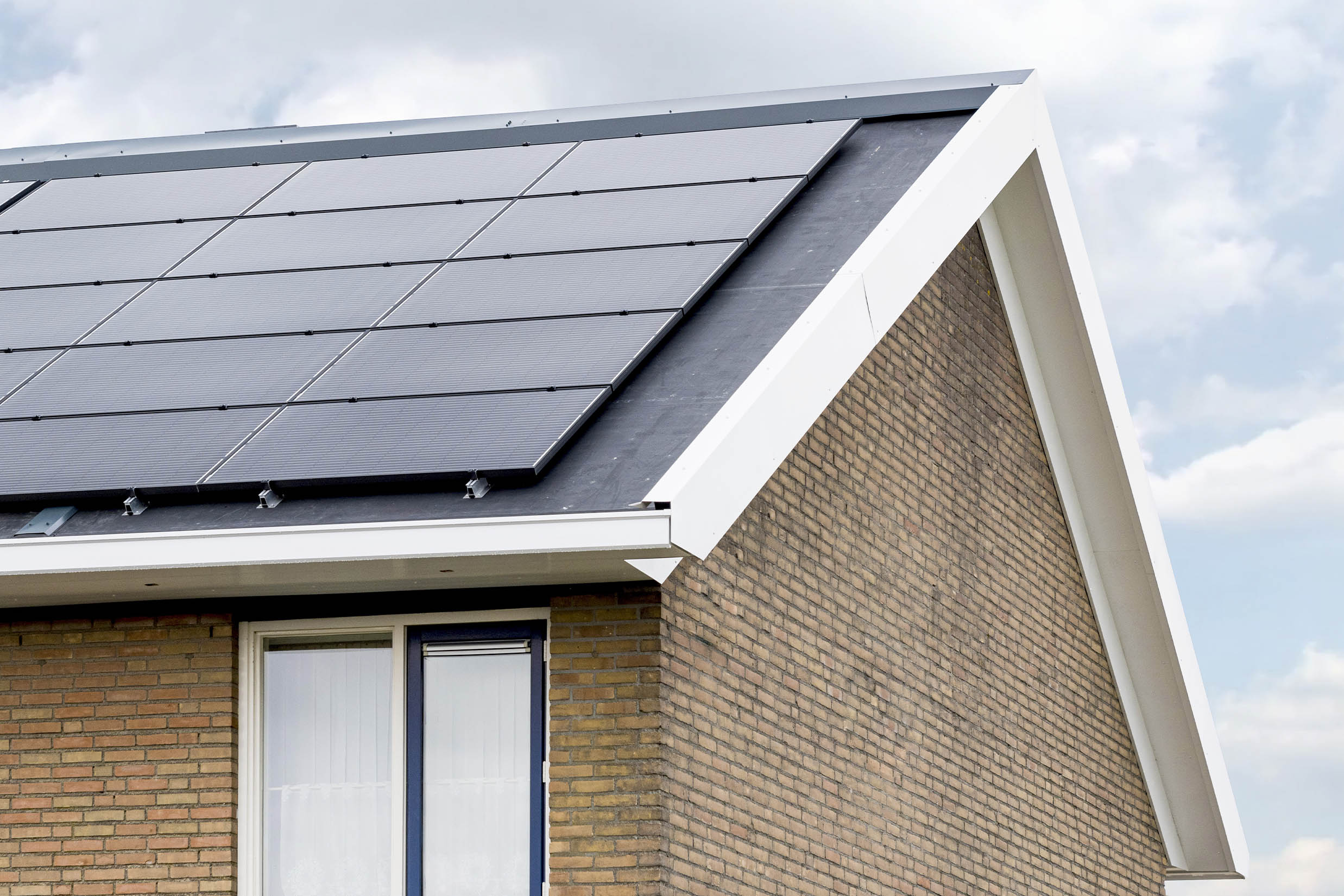 Zijkant van een huis met zonnepanelen als illustratie bij het artikel over Standaard en streefwaarden voor woningisolatie